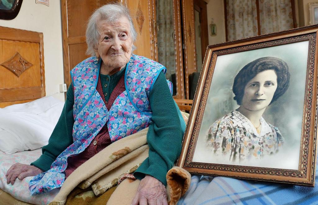 Världens äldsta levande person, italienska Emma Morano, fyller 117 år i dag. Här poserar hon bredvid en bild av sig själv som ung.  (Foto: Antonino Di Marco/AP/TT-arkivbild)