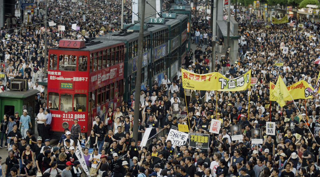 Trams sit stranded as thousands of people block the streets in a huge protest march against a controversial anti-subversion law known as Article 23 in Hong Kong, 01 July 2003. Around 200,000 people marched through Hong Kong streets to coincide with the sixth anniversary of the territory's reversion to Chinese rule, the biggest political demonstration when one million people took to the streets in the wake of the Tiananmen Square massacre in 1989. AFP PHOTO/Peter PARKS (Photo credit should read PETER PARKS/AFP/Getty Images)