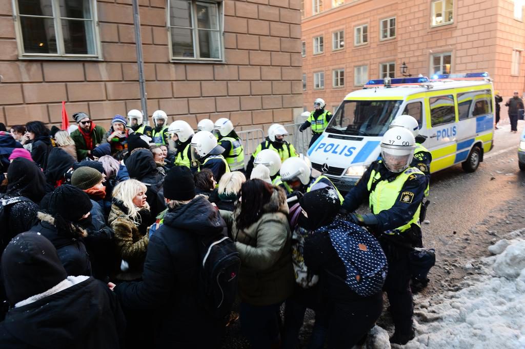 Motdemonstranter hålls på avstånd av polisen. (Foto: Fredrik Sandberg/TT)