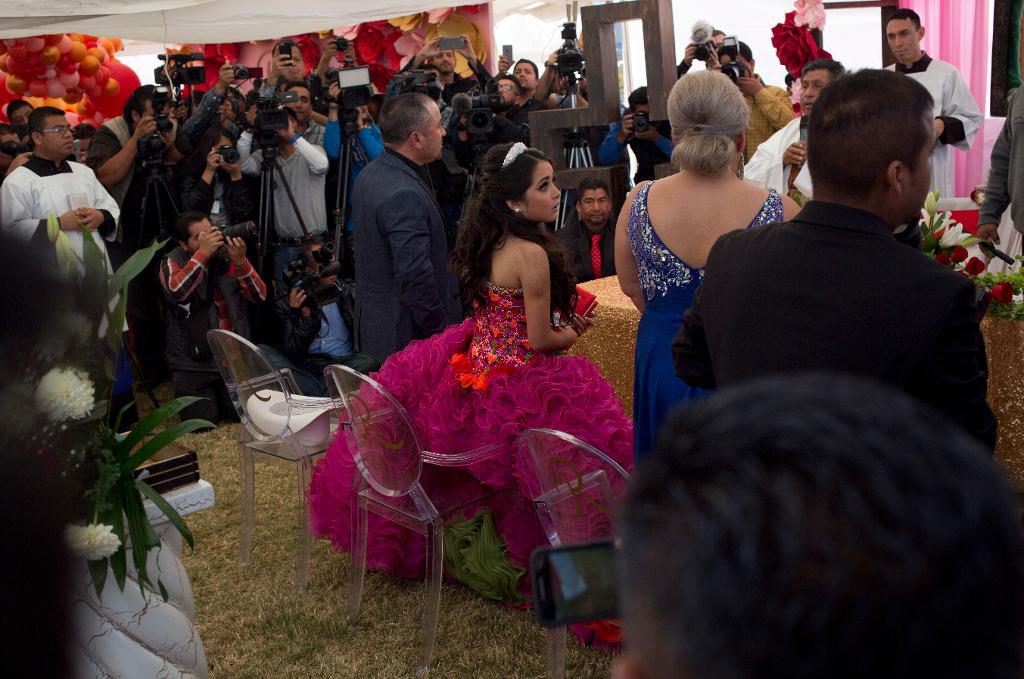 Rubí Ibarra García tittar på sin mor på en mässa under 15-årsfesten. (Foto: Enric Marti/AP/TT)