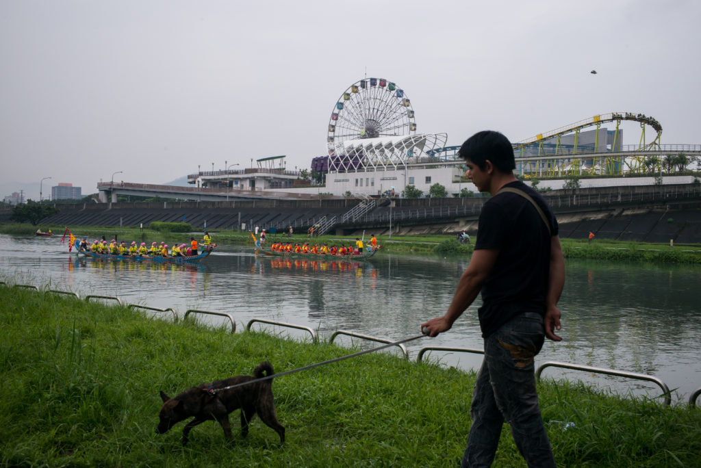 En taiwanes som är ute och går med hunden under drakbåtsfestivalen i huvudstaden Taipei, i juni 2016. (Foto: Billy H.C. Kwok/Getty Images)