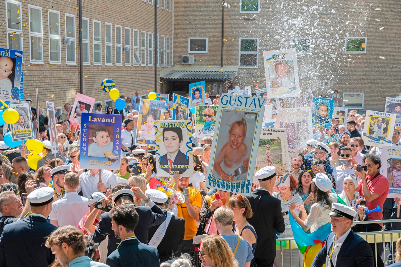 Familj och vänner håller upp plakat när deras nära och kära tar studenten. År 1968 tog de sista eleverna studenten enligt den gamla skolan. Foto: Mikael Damkier/Shutterstock