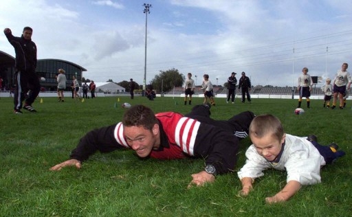 Goda hälsovanor grundläggs i unga år. På bilen ser vi Mark Hammett, professionell rugbyspelare i Nya Zeeland som tränar med en yngre förmåga. (Foto: AFP/Olivier Morin)
