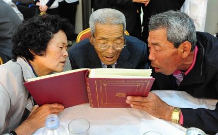 Efter år av väntan fick äntligen pappa Ri Jong-Ryol träffa sina två vuxna barn. Han bor i Nordkorea och barnen i Sydkorea. Ett fotoalbum är bra att ha när man vill visa vad som hänt i ens liv. Här går fadern genom livets väg  tillsammans med sonen Lee Min-Gwan och dottern Lee Sun-Ja. (Foto: AFP)