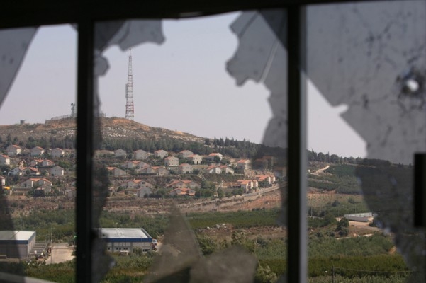 Den israeliska gränsstaden Metulla sedd genom ett fönster i en förstörd lägenhet i den libanesiska staden Kfar Kila. Hizbollahledaren Hassan Nasrallah bad i går, den 27 augusti, om ursäkt för gripandet av de två israeliska soldater, vilket var den tändande gnistan till det månadslånga kriget mellan hans trupper och Israel. (Foto: AFP/Patrick Baz)
