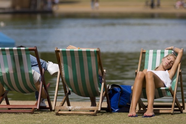 En kvinna vilar i solen vid Serpentine Lake i Hyde Park i centrala London den 27 juli 2014. Vitamin D produceras i kroppen när huden utsätts för solljus. (Foto: Justin Tallis /AFP /Getty Images)