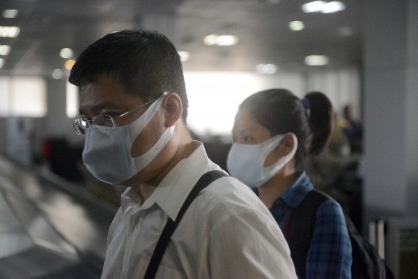 Resenärer bär på skyddande ansiktsmasker vid ankomsten till Murtala Mohammed flygplatsen i Lagos den 11 augusti 2014. (Foto: Pius Utomi Ekpei/AFP/Getty Images)