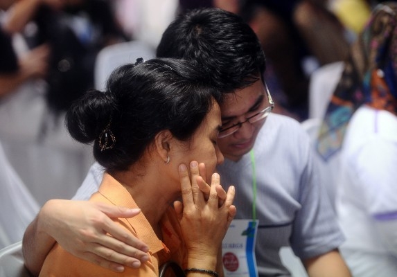 Anhöriga till passagerare på AirAsia flyget QZ 8501, reagerar på nyheten att vrakdelar och kroppar hittats i Surabaya i Indonesien, den 30 december. Vrakdelar och döda kroppar har enligt uppgift siktats i Javasjön under sökningen efter det saknade flygplanet Air Asia flight QZ 8501 som var på väg från Surabaya till Singapore, med 162 personer ombord. Planet förlorade kontakten med flygledningen vid 07:24 lokal tid den 28 december (Foto: Robertus Pudyanto/Getty Images)
