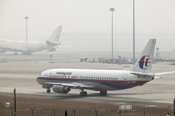 En Boeing 737 flygplan som drivs av Malaysian Airline System Bhd (MAS) syns genom dimman på Kuala Lumpur International Airport (KLIA) i Sepang, Malaysia, fredagen den ​​14 mars, 2014. Indiska styrkor utökade sökandet efter det försvunna Malaysian Airlines Flight 370 med 239 personer ombord, till Bengaliska viken, efter att det kommit fram bevis på att planet kan ha flugit långt efter det att flygledare förlorat kontakten med det för en vecka sedan. (Foto: Charles Pertwee /Bloomberg via Getty Images)