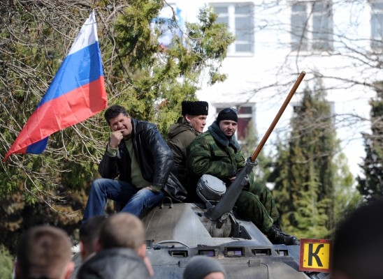 Pro-ryska aktivister sitter på en pansarbandvagn efter att de tagit över den ukrainska flottans högkvarter i staden Sevastopol, på Krimhalvön den 19 mars 2014. Pro-ryska styrkor kvarhöll Ukrainas flottchef samma dag efter att ha tagit över ytterligare två baser på Krim, trots västerländska varningar om att "annekteringen" inte kommer att ske ostraffat.  (Foto: Viktor Drachev/AFP/Getty Images)
