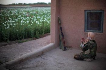 En afghansk nationell armésoldat ber under en patrullrunda nära ett vallmofält i ett talibanfäste i Marjah-område, provinsen Helmand i södra Afghanistan, den 5 april. (Foto: Mauricio Lima / AFP )
