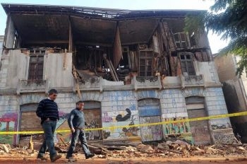 Två män går framför en byggnad i Valparaiso som skadades svårt av en enorm jordbävning i Chile med magnituden 8,8 på Richterskalan den 27 februari 2010. (Foto: Felipe Gamboa / AFP / Getty Images)