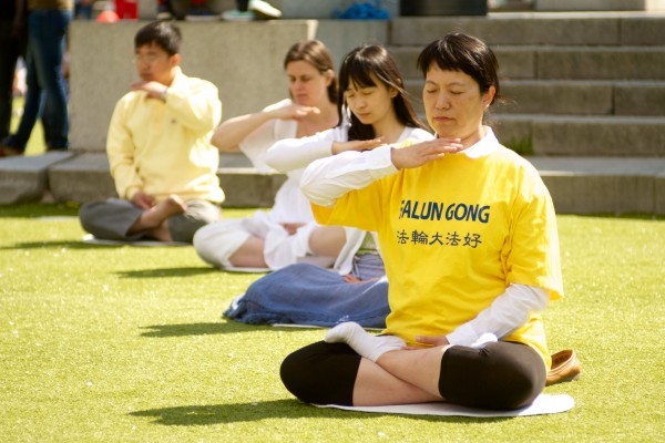 Meditation i stillhet. Solen sken hela dagen och värmde gott i Kungsträdgården i Stockholm lördag den 11 maj. (Foto: Emil Almberg/Eppch Times)
