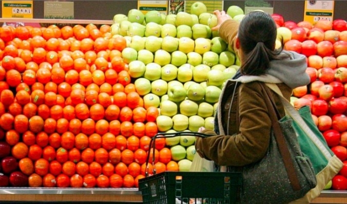 En kvinna väljer äpplen i en butik i New York. Världens första GMO-äpple varken oxiderar och blir brunt.  Arctic-äpplet ska börja säljas i grönsaksaffärer redan i början av 2014.  (Foto: Chernin/Getty Images)