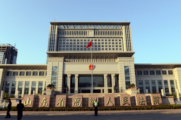 I denna arkivbild står en kinesisk polis vakt utanför Högsta domstolen i Shandong, Jinan, i östra Kina den 24 oktober 2013. (Foto: Goh Chaii Hin / AFP / Getty Images)
