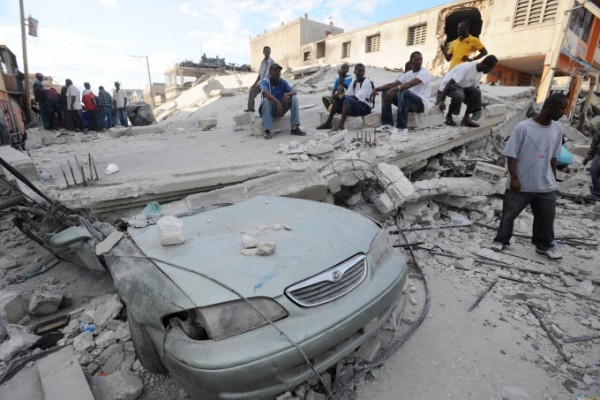 Överlevande står på taket till ett raserat hus i Port-au-Prince, Haiti. (Foto: Juan Barreto / AFP)