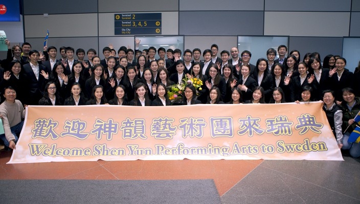Shen Yuns artister poserar med välkomstbanderollen på Arlanda flygplats den 2 april 2015. (Foto: Li Zhihe/Epoch Times)
