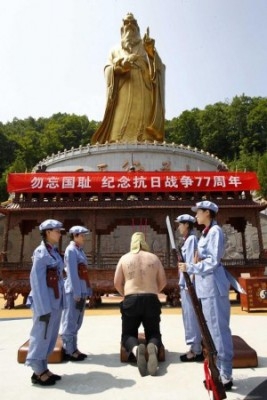 Fyra unga kvinnor spelar upp en scen där man tillfångatar en japansk soldat i Luoyang, i Henanprovinsen, den 7 juli. Det hela skedde i samband med 77-årsdagen av Japans invasion av Kina 1937. (Foto: Skärmdump/news.qq.com)