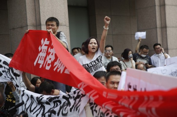 Invånare i Tianjin protesterar utanför det hotell där myndigheterna höll presskonferens i Tianjin den 17 augusti 2015. Foto: STR/AFP/Getty Images