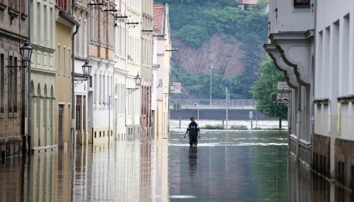 En man går i vattnet från den översvämmade floden Elbe den 9 juni i staden Meissen, Tyskland. (Foto: Kay Nietfeld/AFP)
