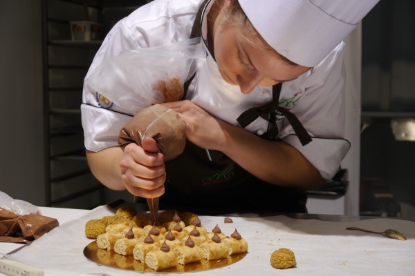 Sara Aasum Hultberg koncentrerad över Petit fours. (Foto: Cecilia Samuelsson/ Epoch Times)
