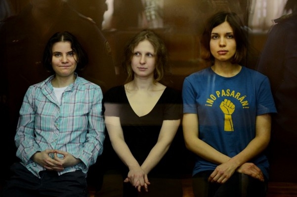 Medlemmarna i det feministiska punkbandet "Pussy Riot" Nadezhda Tolokonnikova (vä), Maria Alyokhina (hö) och Yekaterina Samutsevich (mitten) sitter i en bur med glasvägg under en domstolsförhandling i Moskva den 17 augusti​​. (Foto: Natalia Kolesnikova/ AFP)