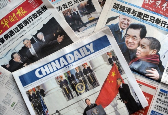 På tidningars första sida i Peking visas Kinas president Hu Jintao och USA:s president Barack Obama under Hus besök i USA den 20 januari 2011. (Foto: AFP/Peter Parks)