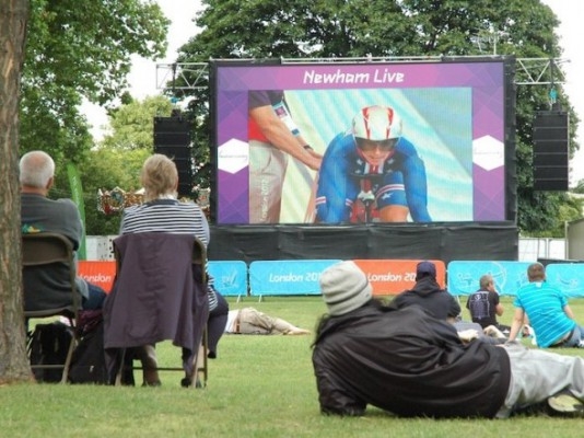 Lokalbefolkningen samlades i West Ham Park i östra London på lördagen för att följa cykeltävlingen på den stora skärmen den 4 augusti. (Foto: Tara MacIsaac/The Epoch Times)
