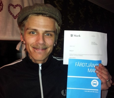
24-årige Adam Hall håller upp sitt färdtjänstintyg. Numera hänvisas han till färdtjänsten om han vill ta sig någonstans. I och med sin hyposomnidiagnos kan han inte längre köra bil. (Foto: Mikaela Persson)                                                