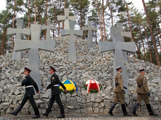 Soldater går förbi kors under en ceremoni i september 2012 i vilken den polske presidenten, Bronislaw Komorowski, och hans ukrainske motsvarighet Viktor Janukovitj, avtäckte ett minnesmärke för de tusentals polska officerer som mördades av Stalins hemliga polis 1940 och begravdes i massgravar utanför Kiev. (Foto: Inna Sokolovskaya/AFP/GettyImages)