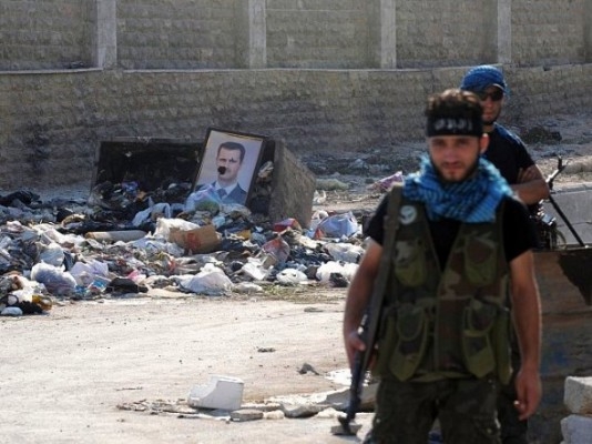 Medlemmar av den väpnade syriska oppositionen vaktar en kontrollpunkt under sammandrabbningar med regimlojalister i den oroliga staden Aleppo i norra Syrien, den 25 juli. (Foto: Bulent Kilic/AFP/GettyImages)