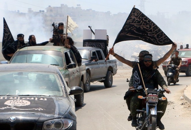 Anhängare av Nushrafronten en utlöpare till al-Qaida håller en islamistisk flagga när de kör genom Aleppo på väg mot fronten i maj 2015. (Foto: Fadi al-Halabi/AFP/Getty Images)