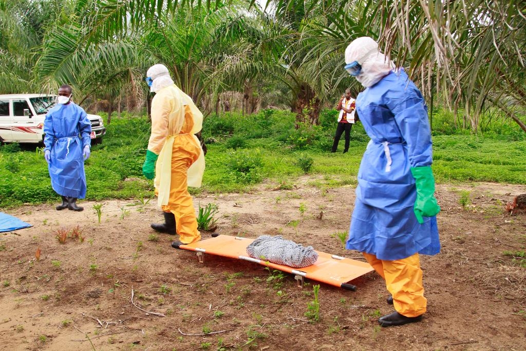 Hälsovårdsarbetare i Dubreka, Guinea, omhändertar ett nyfött barn som tros ha dött av ebola. (Foto: Youssouf Bah/AP/TT-arkivbild)