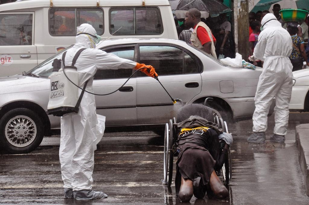Hälsoarbetare desinfekterar kroppen av en person som tros ha dött i ebola i Liberias huvudstad Monrovia i september 2014. (Foto: Abbas Dulleh/AP/TT-arkivbild)