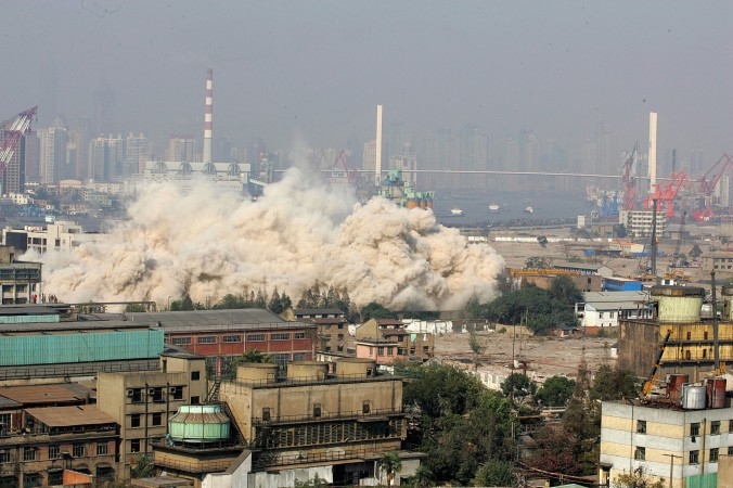 Hus rivs med hjälp av sprängning i Shanghai 2006. I Kina går stora resurser till spillo på att nya eller inte ens färdigbyggda hus rivs. (Foto: China Photos/Getty Images)