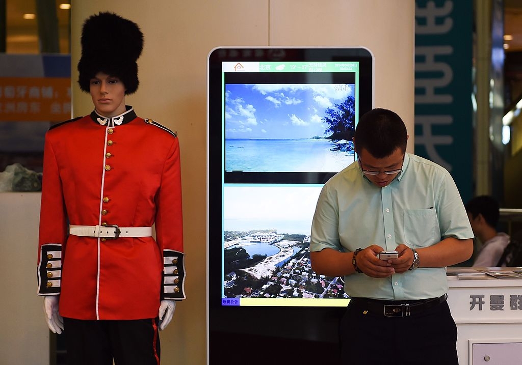Många företag erbjuder investeringar till rika kineser. I detta shoppingcenter i Peking annonseras mark och bostäder på Kajmanöarna ut. (Foto: Greg Baker /AFP/Getty Images)