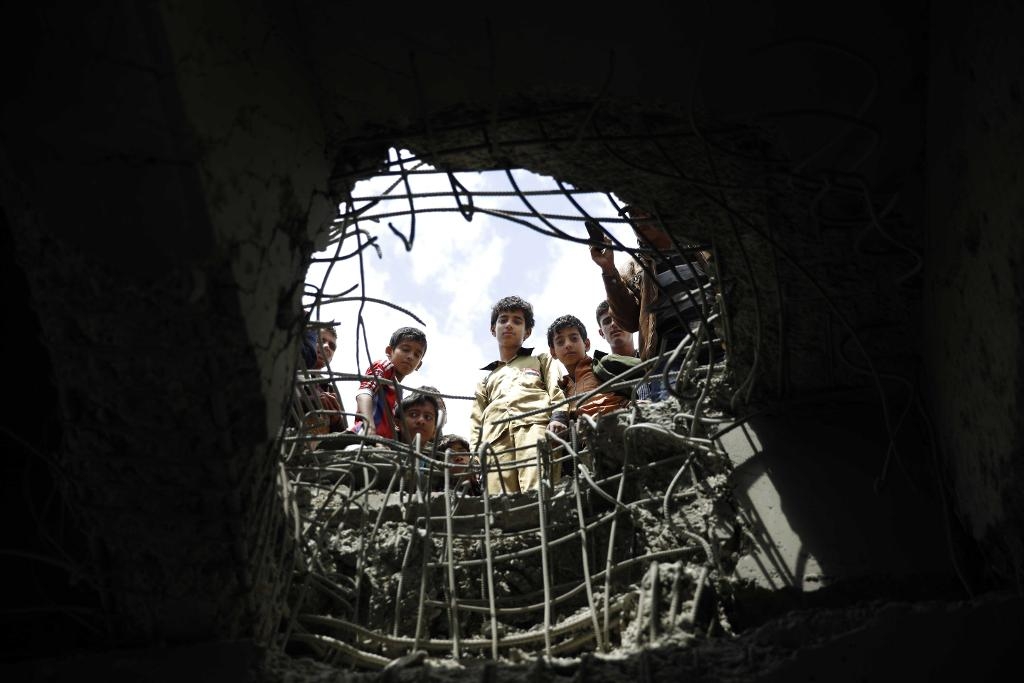 
Några pojkar tittat ner i en krater som bildats vid en flygbombning av Sanaa i Jemen i mars i år. (Foto: Hani Mohammed /AP/TT)