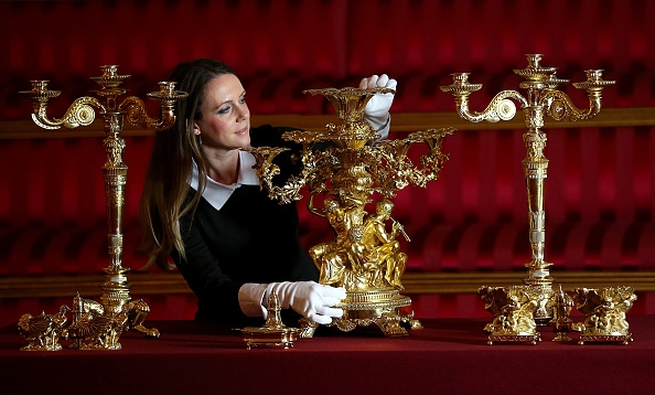 En anställd putsar ljusstakarna inför sommarsäsongen på Buckingham Palace. Nu söker hovet en ny hushållerska. (Foto: Carl Court/Getty Images)