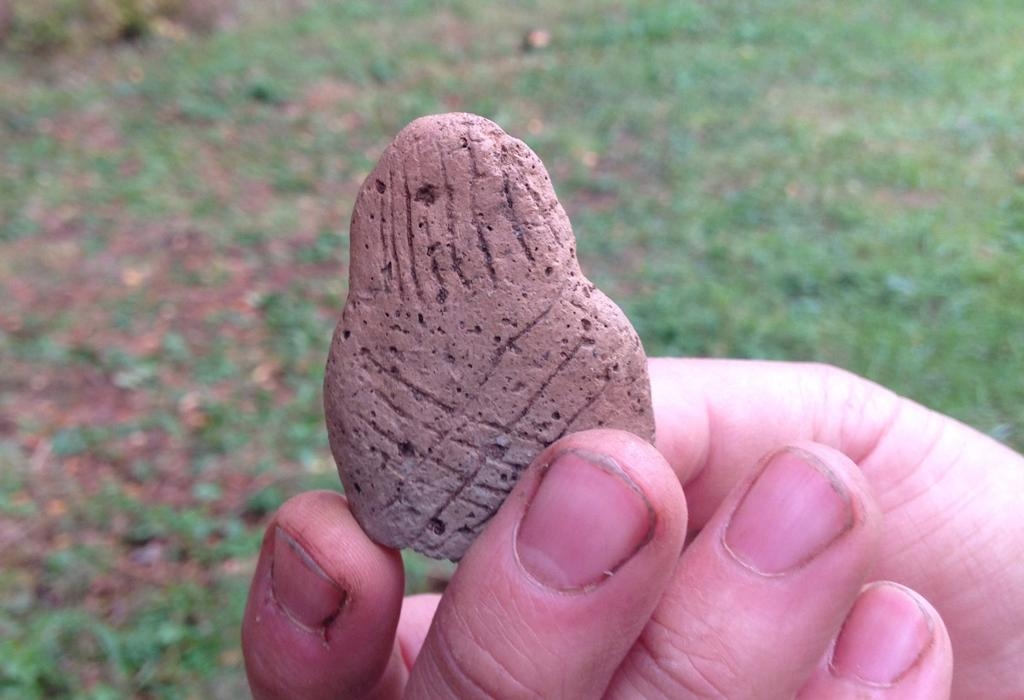 Lerfigur med forntida frisyr. De korslagda ränderna på ryggen föreställer förmodligen detaljer på klädedräkten.
(Arkeologerna/Sveriges historiska museer/TT)