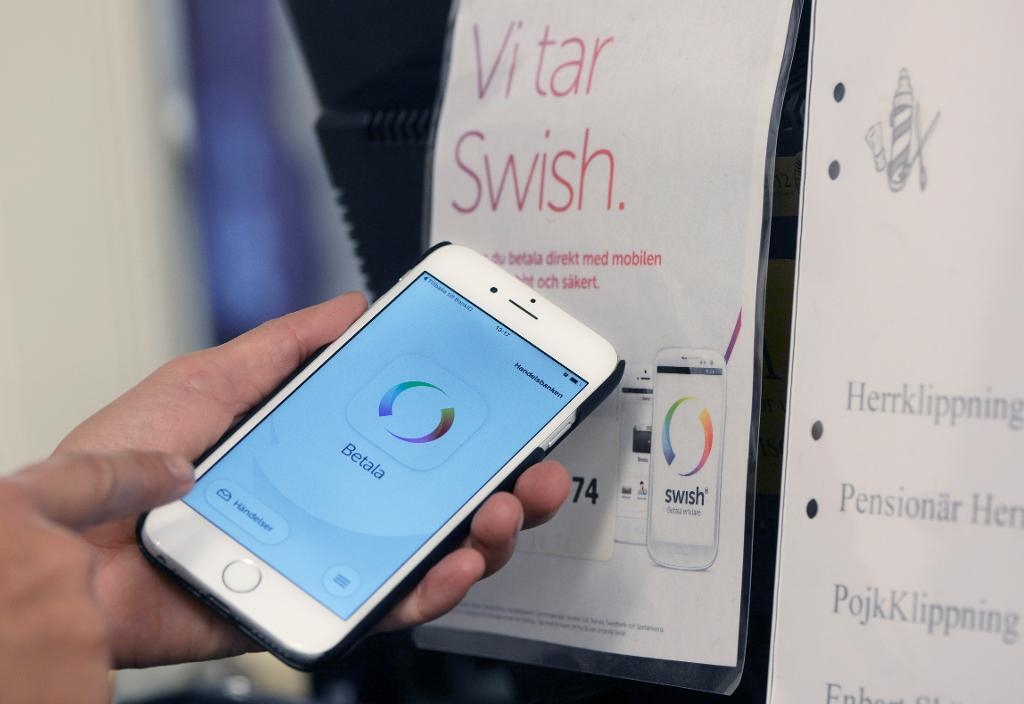 En person betalar med Swish på en frisörsalong. (Foto: Fredrik Sandberg/TT)