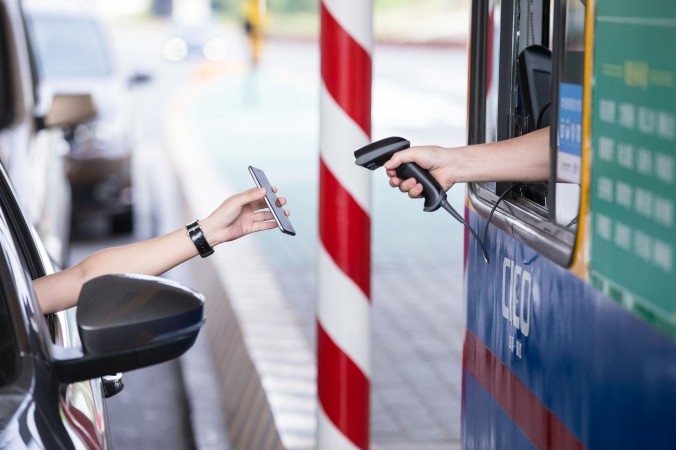 En förare använder Alipay med telefonen för att betala vägtull på motorvägen mellan Hangzhou och Ningbo. (Foto: STR/AFP/Getty Images)