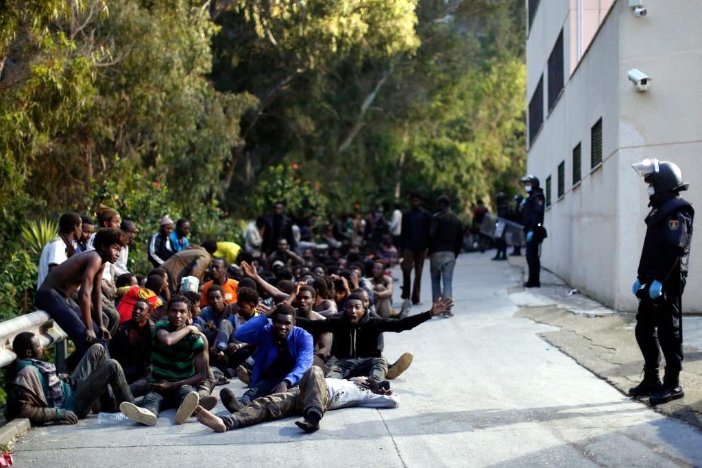 
Migranter bevakas av spansk polis efter gränsstormningen i förra veckan.  Foto: Jesús Morón