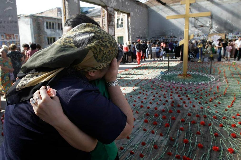 
Anhöriga sörjer dödsoffren för gisslandramat i Beslan under en minneshögtid i ruinerna av skolbyggnaden. Foto: Ivan Sekretarev/AP/TT-arkivbild                                            