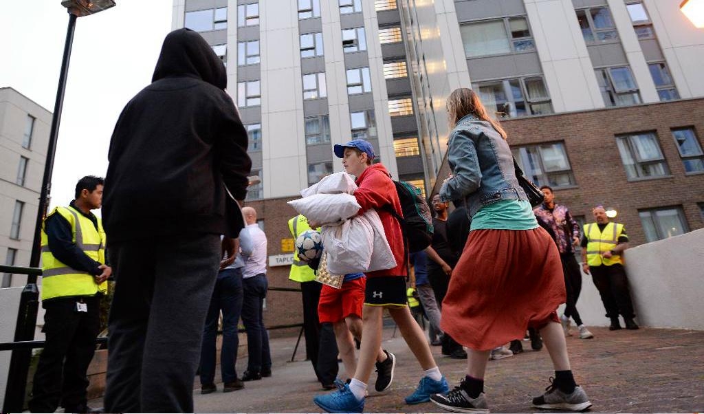 Boende lämnar ett av höghusen i Camden, London. Foto: Stefan Rousseau/PA/AP/TT