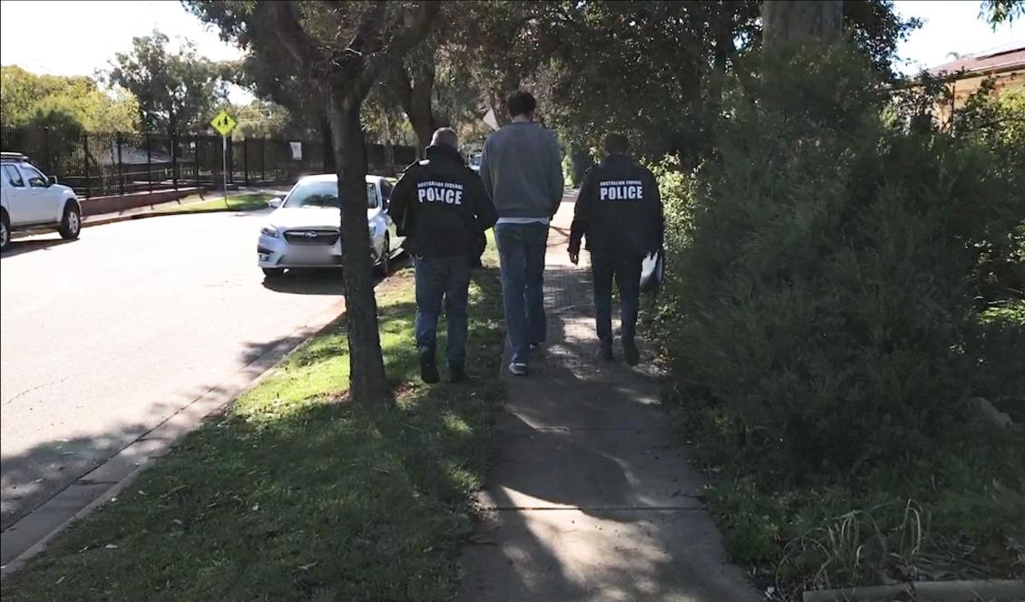 
Australiens federala polis AFP griper en man i en förort till Ingle Farm i Adelaide i Australien. Flera hundra personer runt om i världen har gripits i en global insats. Foto: Australian Federal Police (AFP).                                            
