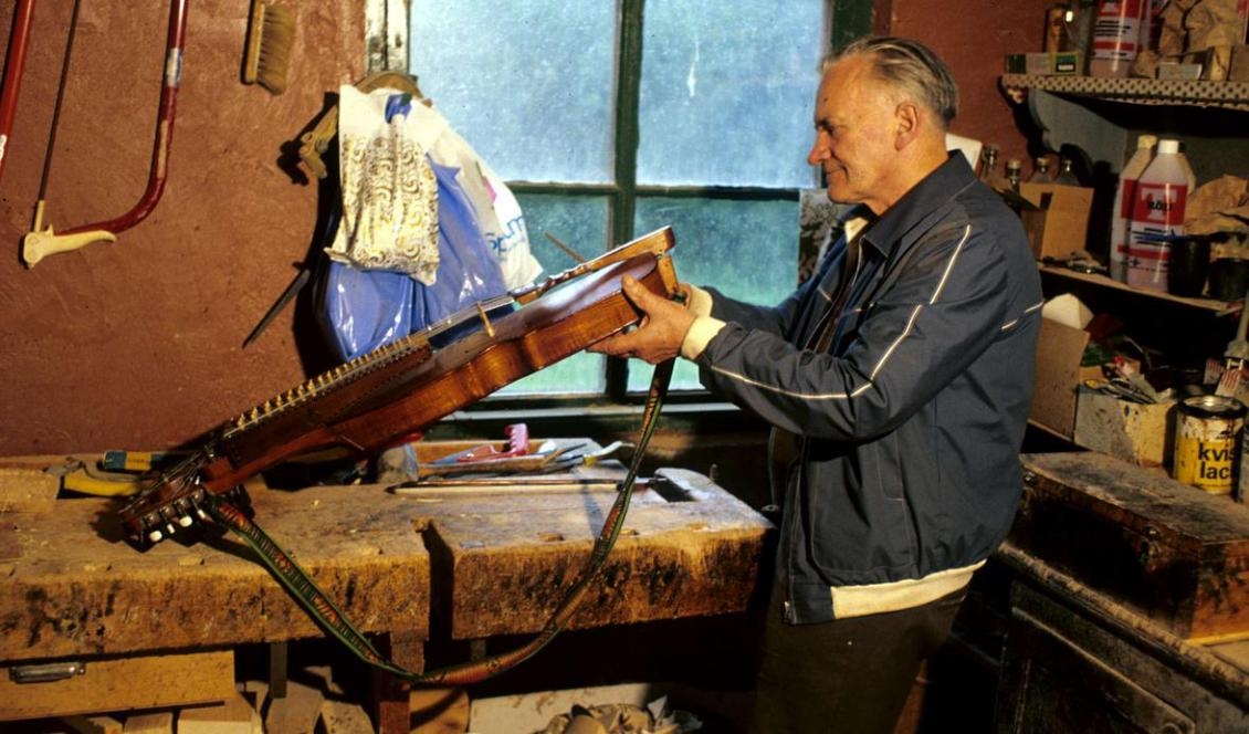 Riksspelman Eric Sahlström spelade en avgörande roll för nyckelharpans utveckling och utbredning i Sverige. Här i sin verkstad i Tobo. Foto: okänd/Upplandsmuseet
