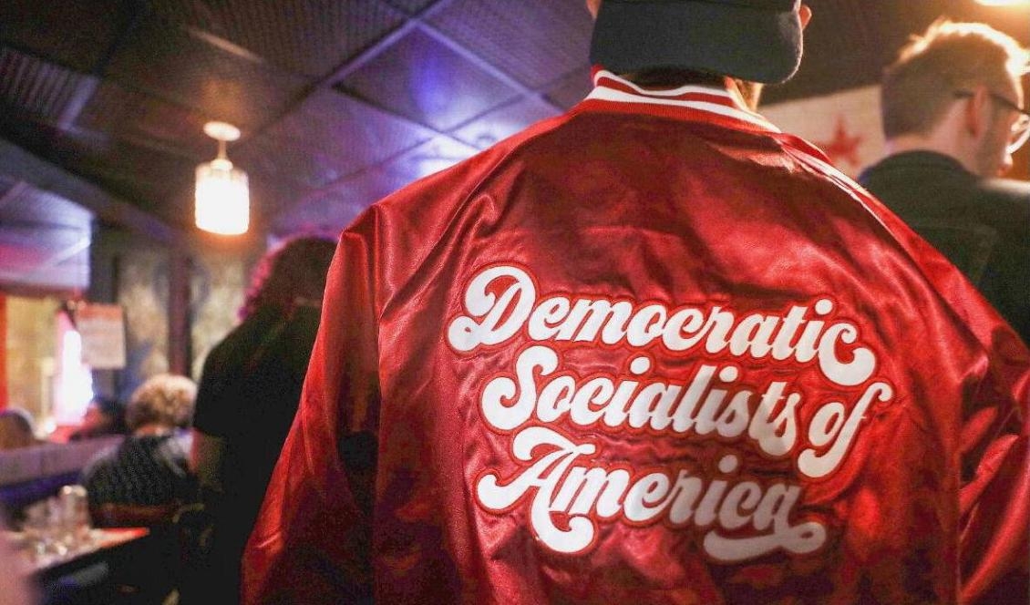 En man bär en jacka med märke från Democratic Socialists of America, en socialistisk grupp som fått allt mer inflytande i amerikansk politik på senare år. Washington DC, 2020. Foto: Mario Tama/Getty Images
