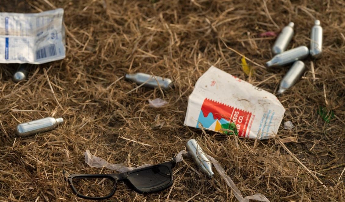 Patroner innehållande lustgas ligger slängda på marken efter en musikfestival. Lustgas har blivit ett allt populärare berusningsmedel bland unga i Sverige. Foto: OLI SCARFF/AFP via Getty Images