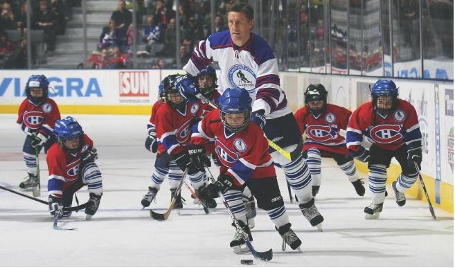 


Hockeylegendaren Börje Salming omgiven av knattespelare iförda matchtröjor med NHLlaget Montreal Canadiens emblem under en uppvisningsmatch. Foto: Bruce Bennett/Getty Images                                                                                                                                    