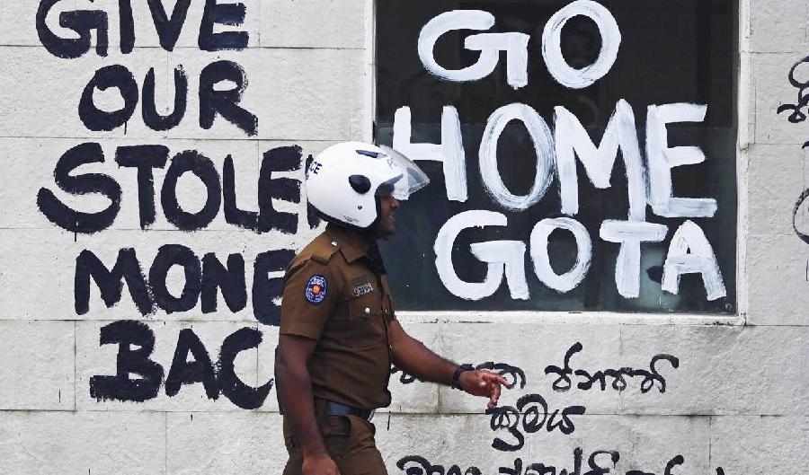 
I juli svors Sri Lankas tidigare flerfaldiga premiärminister Ranil Wickremesinghe in som president. Bakom polisen polisen ses slagord mot landets regering. Foto. Arun Sankar/AFP via Getty Images                                            